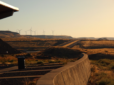 [Windmills atop the ridge to the left as seen from the scenic rest stop. One can also see the interstate and the wall separating the rest stop from the vegetation beside the river.]